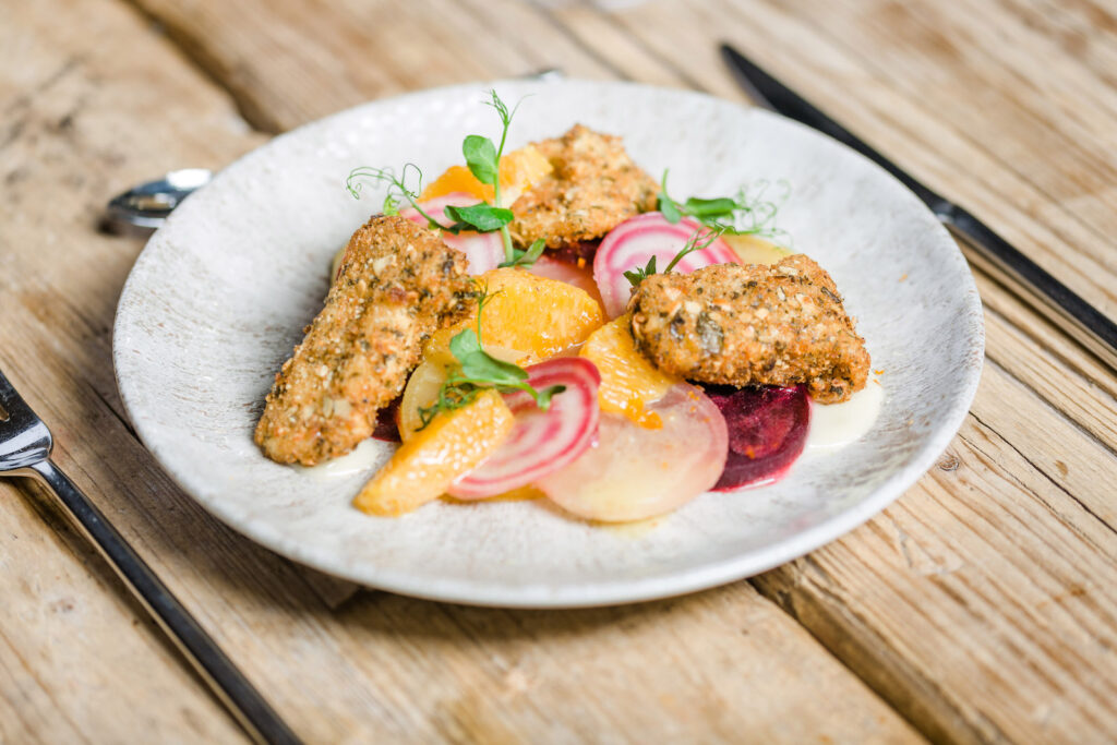 Serviervorschlag Ziegenkäse-Camembert mit gebackenen Kürbiskernen, Orangen-Senf-Vinaigrette und Bunter Bete